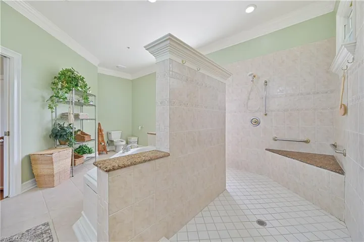 Full bathroom with a tile shower, tile patterned floors, ornamental molding, and recessed lighting
