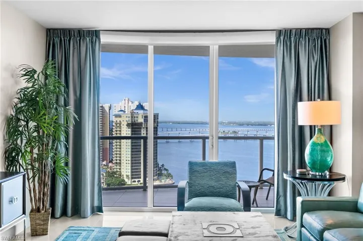 Living area with a water view, expansive windows, and tile patterned floors