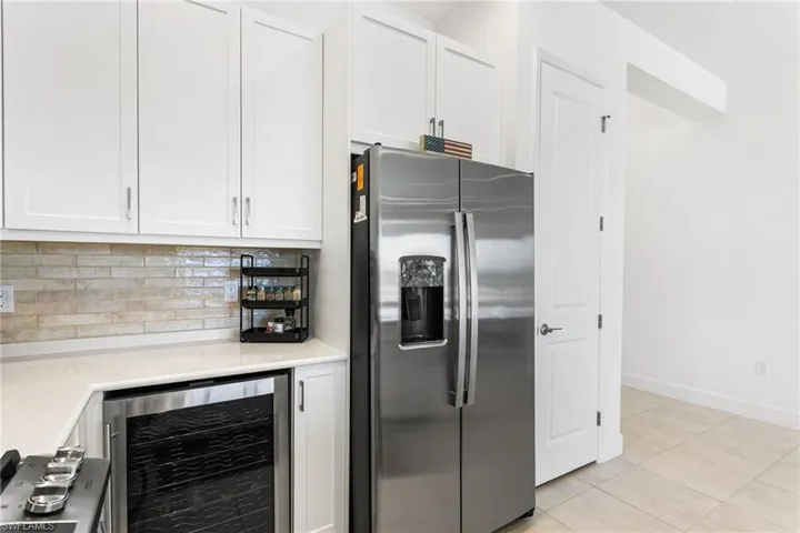 Modern kitchen featuring white shaker cabinetry and a stainless steel side-by-side refrigerator