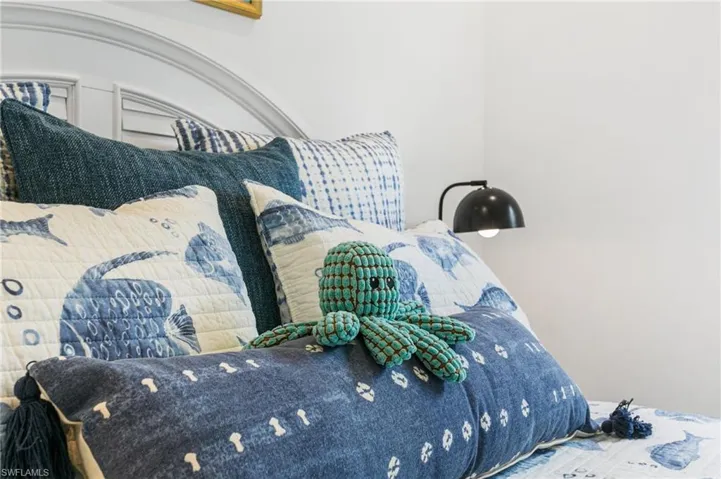 White paneled headboard with an arched top, featuring a built-in wall sconce with a matte black fixture