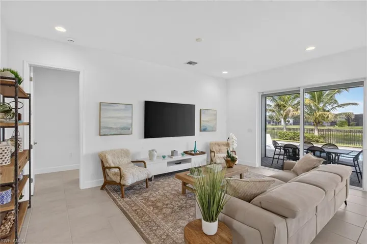 Spacious living area featuring large format tile flooring, recessed lighting, and direct access to an outdoor patio through sliding glass doors