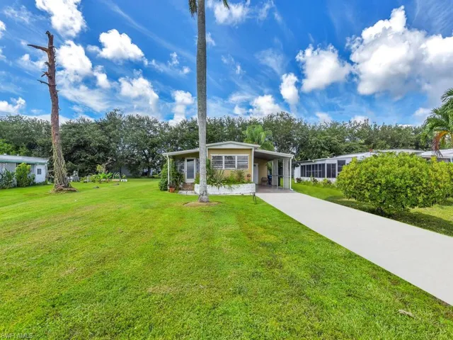 View of front of home featuring a front lawn and a carport