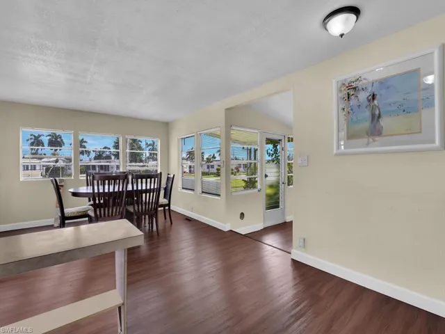 Dining space featuring a textured ceiling, lofted ceiling, and dark hardwood / wood-style floors