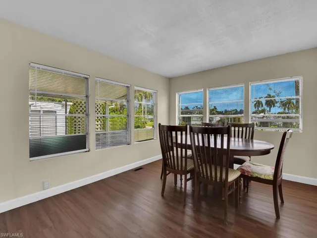 Dining area with a textured ceiling, a wealth of natural light, and dark hardwood / wood-style floors