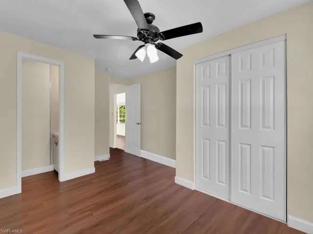 Unfurnished bedroom with ceiling fan, dark hardwood / wood-style floors, and a closet
