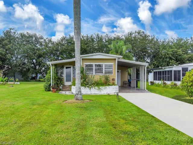 View of front facade with a front lawn and a carport