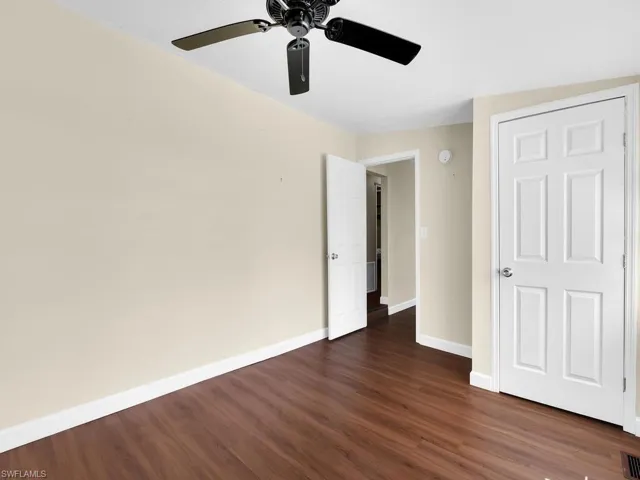 Unfurnished bedroom featuring ceiling fan and dark hardwood / wood-style flooring