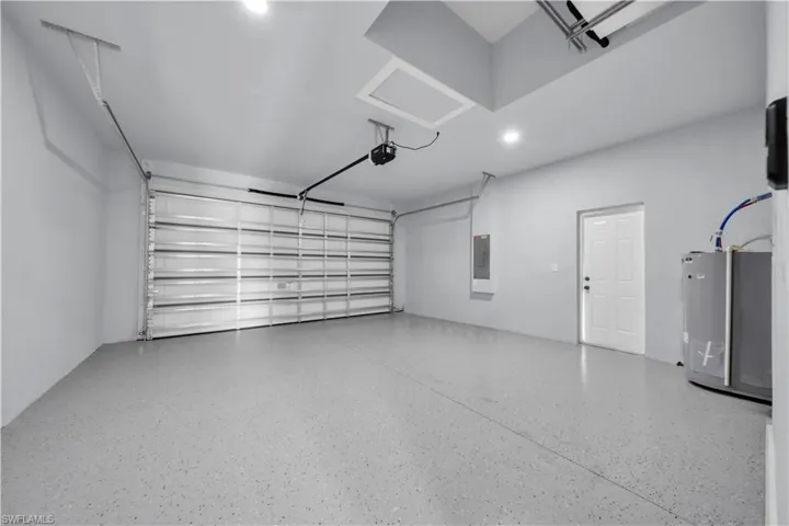 Spacious garage with an epoxy-coated concrete floor, an automatic overhead door, and recessed lighting