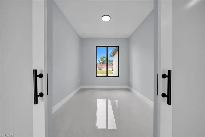Recessed ceiling lighting, large window, sleek black window trim, light gray wall finishes, and light-toned tile flooring