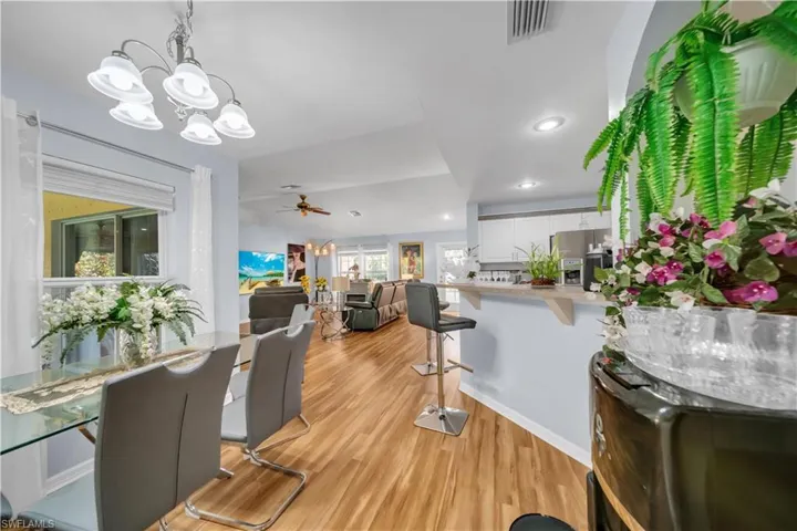 Dining area featuring light wood finished floors, a ceiling fan, a chandelier, and recessed lighting