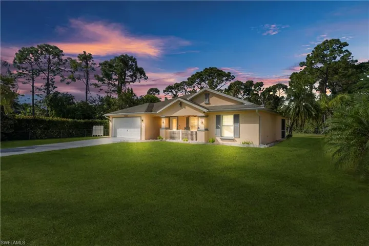 Ranch-style house with driveway, a garage, and stucco siding