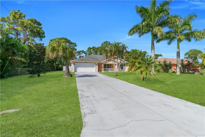Single story home featuring concrete driveway and an attached garage