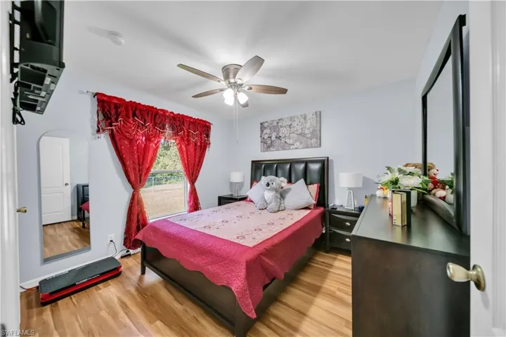 Bedroom with light wood-type flooring, a ceiling fan, and arched walkways