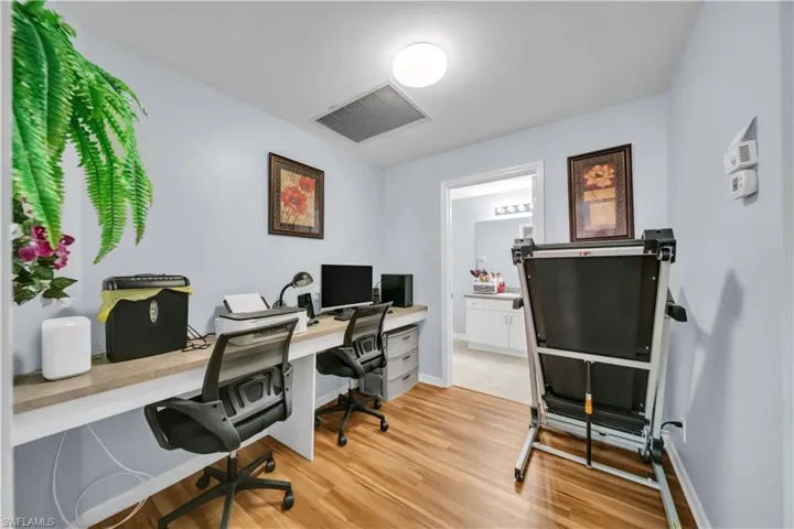 Home office with light wood-style flooring and baseboards