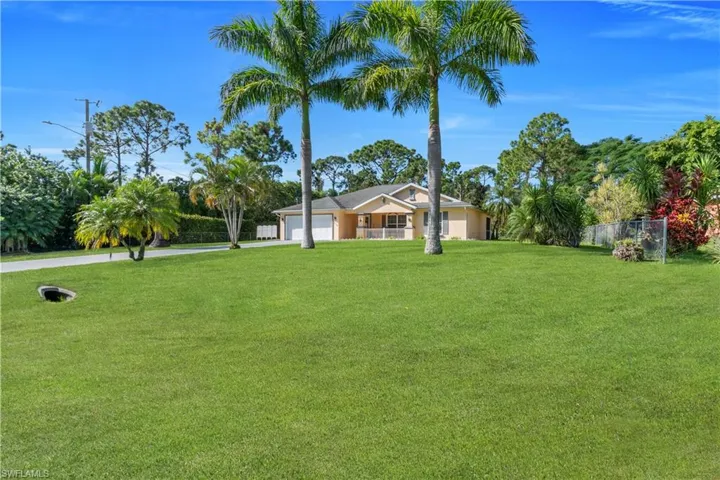 View of yard with a garage and concrete driveway