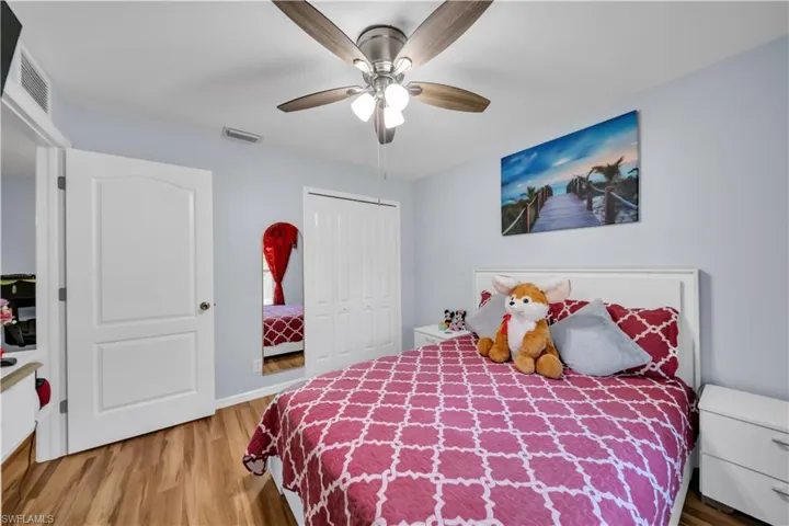 Bedroom with light wood-type flooring, a closet, and a ceiling fan