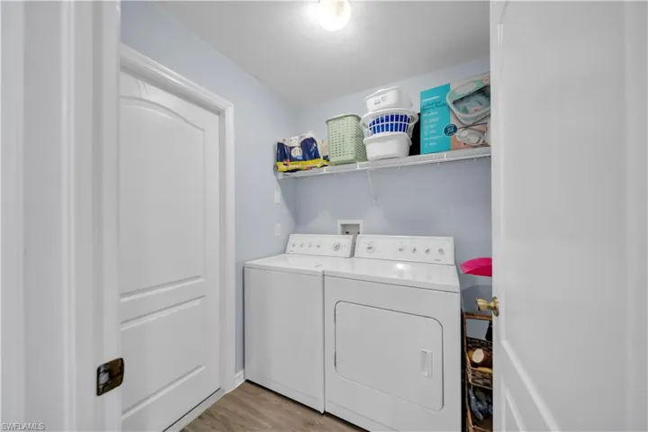 Laundry room with light wood-style flooring and washer and clothes dryer