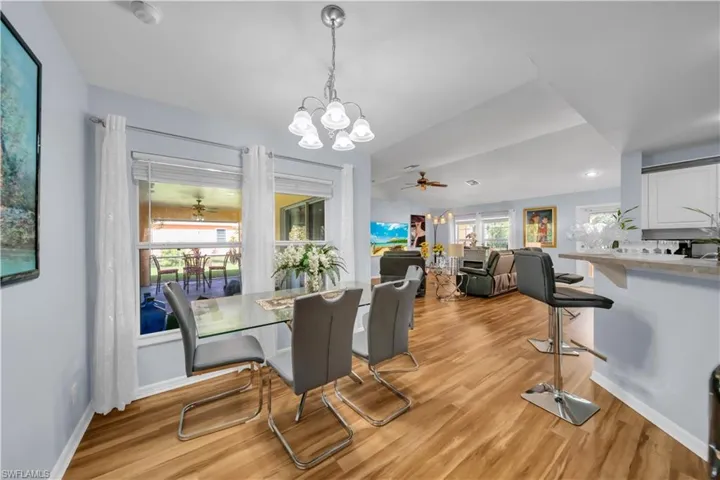 Dining area featuring ceiling fan, light wood-style floors, and a chandelier