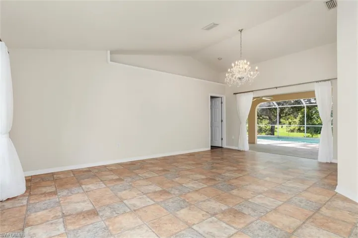 Living room and formal dining area featuring high vaulted ceiling and a chandelier