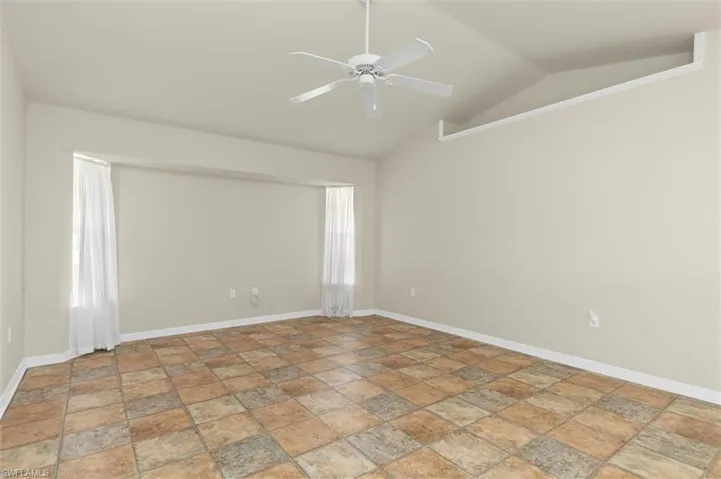 Family room featuring vaulted ceiling and ceiling fan