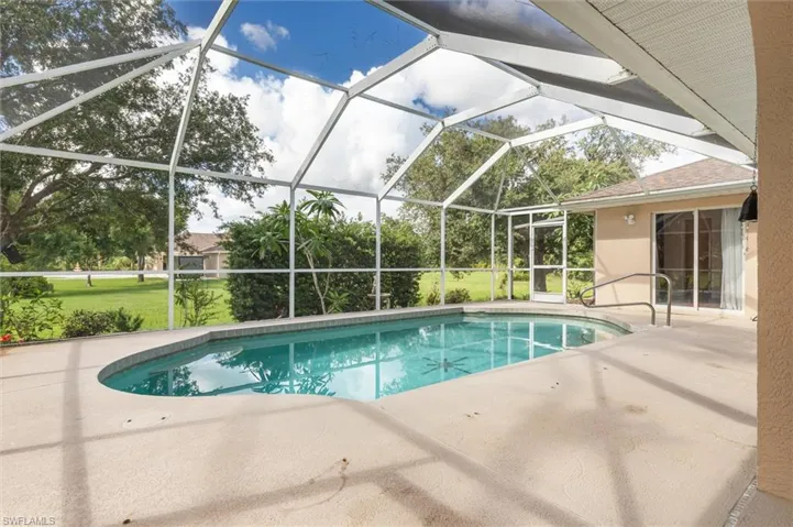 View of swimming pool featuring a patio and screen enclosure