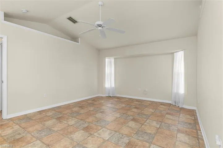 Room featuring a healthy amount of sunlight, ceiling fan, vaulted ceiling, and light patterned floors