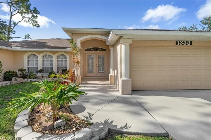 View of exterior entry featuring a garage and french doors