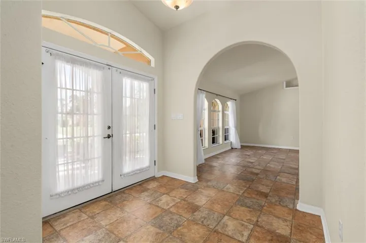 Foyer featuring French doors and vaulted ceiling