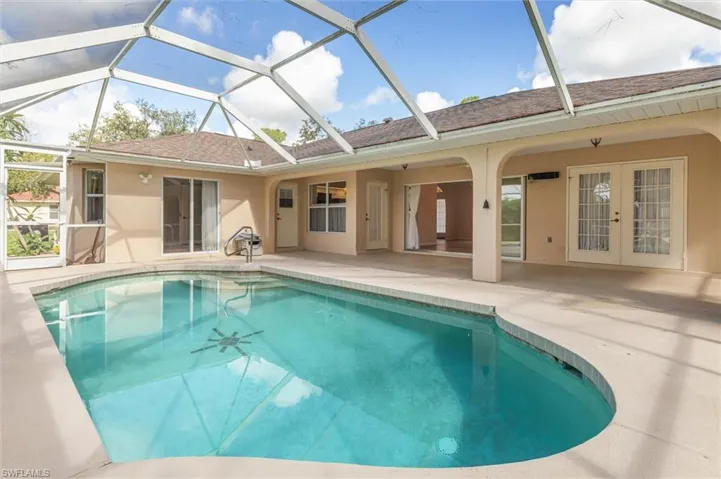 View of swimming pool with a patio and screen enclosure