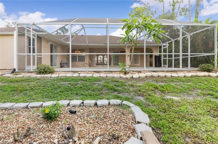 Rear view of property with a patio area and a lanai
