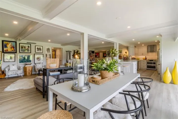 Dining room with ornamental molding, beamed ceiling, and light hardwood / wood-style floors