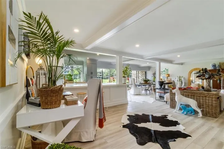 Dining room with crown molding, light hardwood / wood-style flooring, and beam ceiling