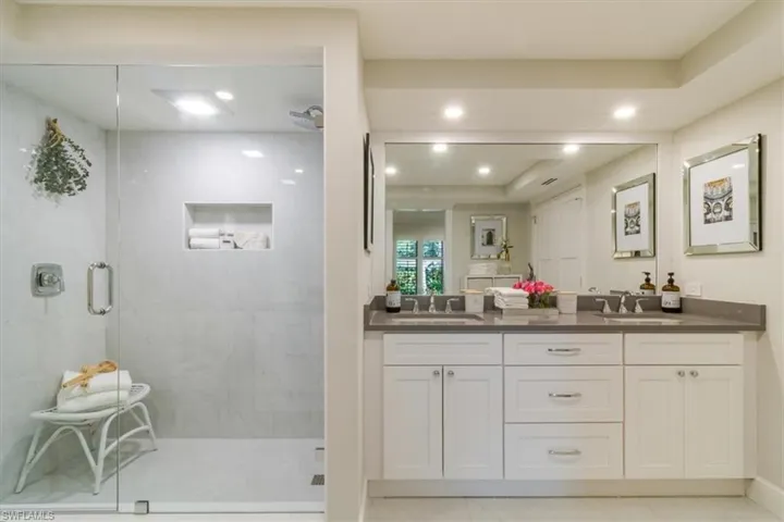 Bathroom with vanity, a raised ceiling, an enclosed shower, and tile patterned floors