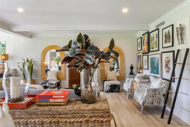 Living area featuring crown molding, light hardwood / wood-style flooring, and beam ceiling