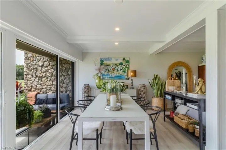 Dining room with light hardwood / wood-style flooring, ornamental molding, and beam ceiling