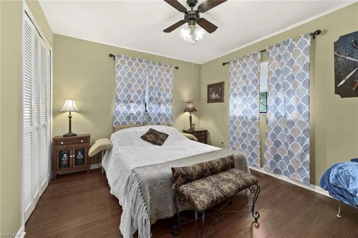 Bedroom with wood finished floors, baseboards, ceiling fan, and a closet
