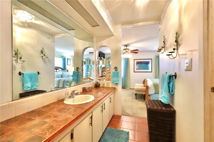 Bathroom with tile floors, crown molding, vanity, and ceiling fan