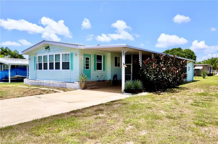 View of front facade with a carport and a front yard