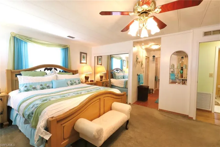 Carpeted bedroom featuring ceiling fan