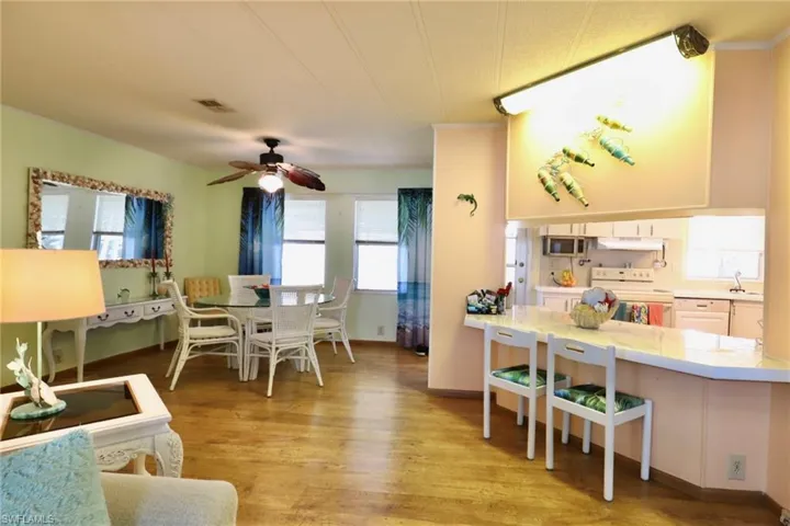Dining area with ceiling fan, light wood-type flooring, and sink