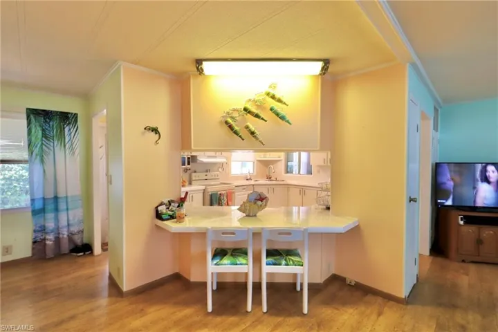 Kitchen featuring crown molding, sink, white range with electric cooktop, and hardwood / wood-style flooring