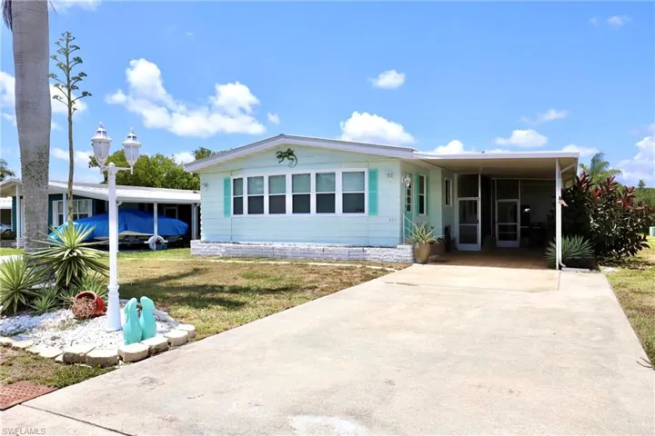 View of front of home with a front yard and a carport