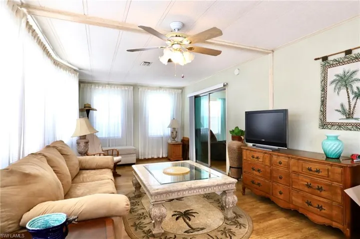 Living room with crown molding, hardwood / wood-style flooring, and ceiling fan