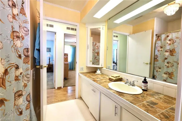 Bathroom featuring oversized vanity, tasteful backsplash, tile floors, and crown molding