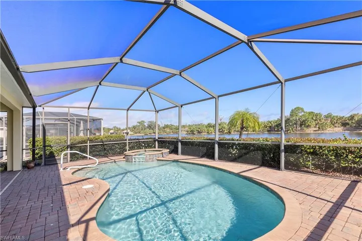 View of swimming pool featuring a lanai, a water view, an in ground hot tub, and a patio