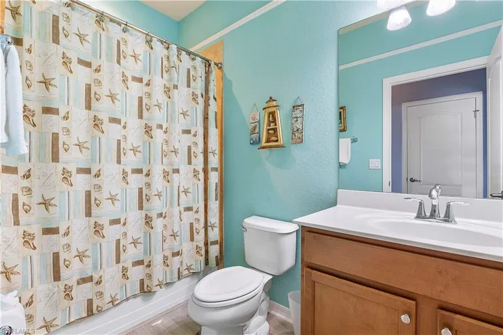 Full bathroom with shower / bath combination with curtain, toilet, and vanity