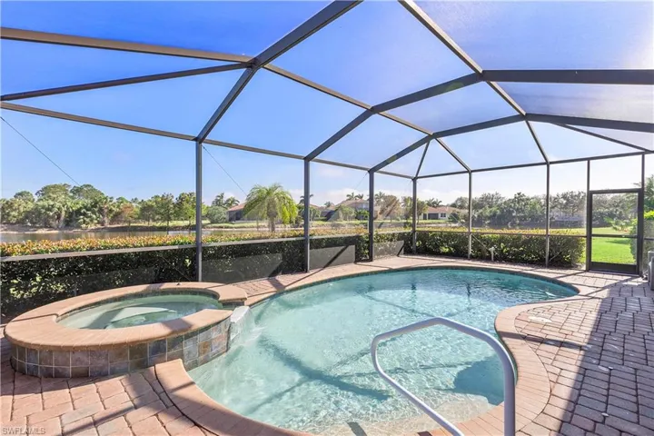 View of pool with an in ground hot tub, a patio, and a lanai