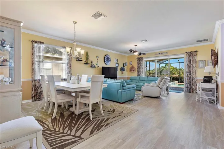 Dining area featuring ornamental molding, light hardwood / wood-style floors, and an inviting chandelier