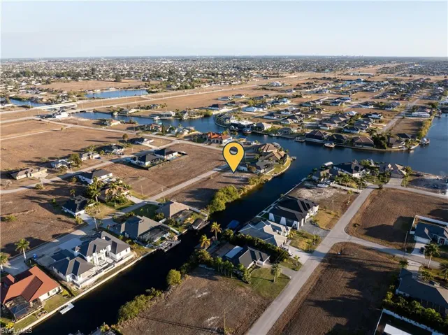 Aerial view of property and surrounding area with a nearby body of water and nearby suburban area