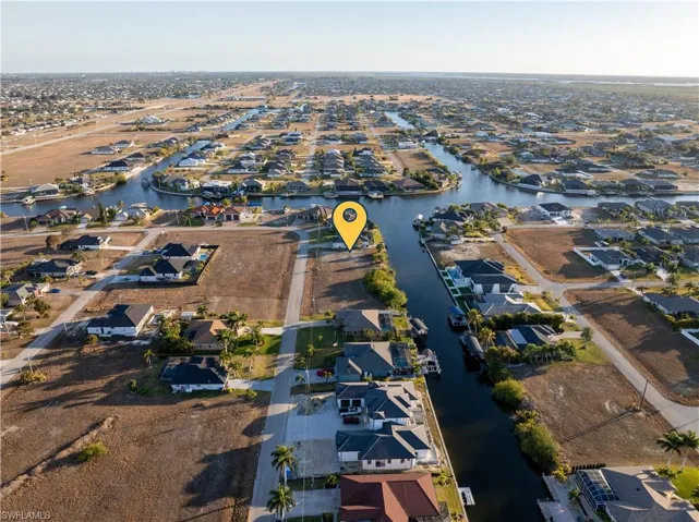 Aerial view of property and surrounding area with a large body of water and nearby suburban area